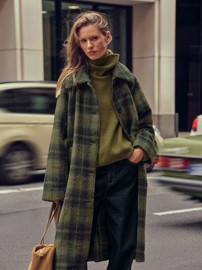 Modelka kobieca nosi Rollkragenpullover mit Rippstrickmuster aus Wolle - curated by Maja Weyhe od Style Icon Collection, zielony, strukturalny wzór, luźny krój, czysta wełna, golf, wydłużone ramiona, widok całej sylwetki z przodu.