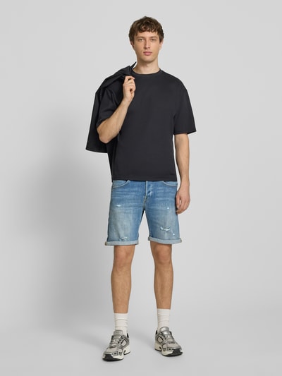 Männermodel trägt Jeansshorts mit Umschlag Modell 'RICK' von Jack & Jones, hellblau, Baumwoll-Mix mit Stretch-Anteil, Regular-Fit, Ganzkörperansicht von vorne.