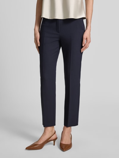 Vrouwenmodel draagt Slim Fit Bundfaltenhose met Viskose-Anteil Modell 'RANA' van Weekend Max Mara, effen donkerblauw, high waist, webstof, met label stitching, riemlussen, schuifhaaksluiting, knoop, blinde ritssluiting, zij- en achterzakken, detailopname van de voorkant