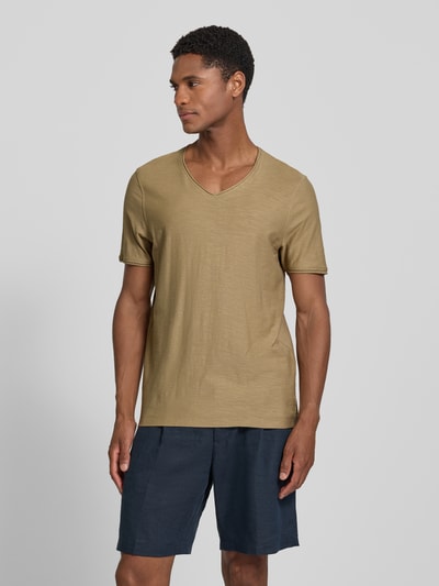 Mężczyznę model nosi T-Shirt mit V-Ausschnitt und Rollsaum von MCNEAL, kolor khaki, bawełna, krój regular fit, długość tyłu 81 cm, widok całej sylwetki z przodu.