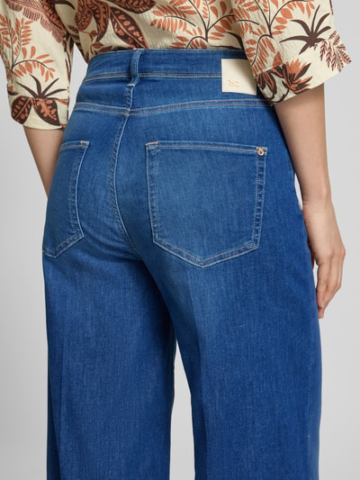 Frauenmodel trägt Wide Leg Jeans in verkürzter Passform Modell 'SVENTY 7/8' von Raffaello Rossi aus Baumwoll-Lyocell-Mix im Used-Look, kräftiges Blau, leichte Struktur, Detailaufnahme Rückansicht.