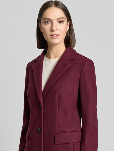 Frauenmodel trägt Regular Fit Mantel mit 2-Knopfleiste von Christian Berg Woman Selection in Bordeaux mit Reverskragen und Pattentaschen, Nahaufnahme Oberkörper.