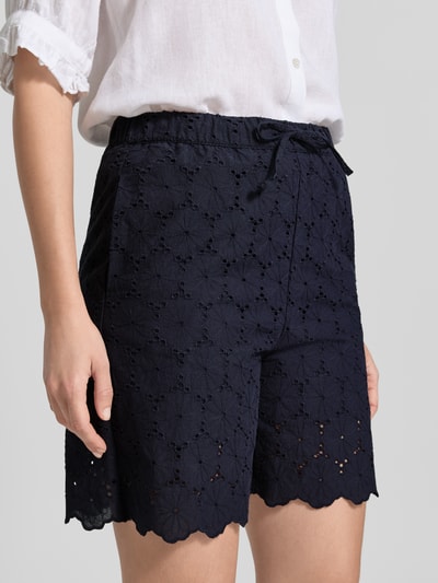 Frauenmodel trägt Bermudas mit Lochstickerei und Eingrifftaschen von Christian Berg Woman, Reine Baumwolle, Loose-Fit, Dunkelblau, Kordelzug-Bund, Nahaufnahme Oberkörper.