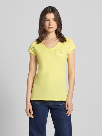 Kobiece modelka nosi damski t-shirt z bawełny, krój regular fit, dekolt w serek, brustasza, model 'GS23' od G.I.G.A. DX, długość tyłu 64 cm w rozmiarze 36, jasny żółty kolor, gładka faktura, widok całej sylwetki z przodu.