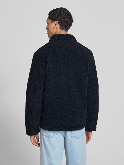 Männermodel trägt Regular Fit Hemdjacke mit Brustleistentaschen von Marc O'Polo DENIM in Schwarz, weiche Teddy-Struktur, Ganzkörperansicht Rückansicht.