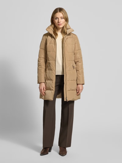 Kobiece model prezentuje beżowy Steppmantel mit Stehkragen od Lauren Ralph Lauren, taliowany krój, zapięcie na zamek, widok z przodu, Ganzkörperansicht.