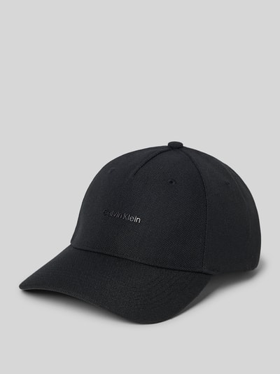 Produktfoto, schwarze größenverstellbare Cap mit Logo von CK Calvin Klein, verstärkter Schirm, strukturierte Oberfläche, auf grauem Hintergrund