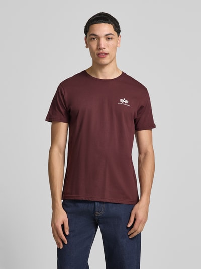 Männermodel trägt T-shirt met labeldetails model 'BASIC' van Alpha Industries, puur katoen, recht model, ronde hals, ruglengte maat M 67 cm, Ganzkörperansicht von vorne.