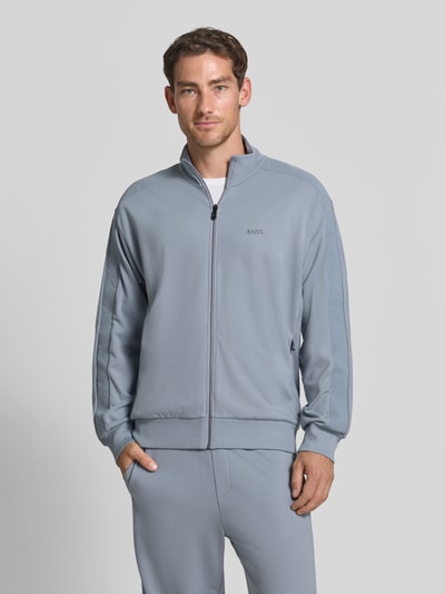 Männermodel trägt Regular Fit Sweatjacke aus Viskose-Mix Modell 'SW_Union Tape FZ' von BOSS Green in Hellgrau, Ganzkörperansicht von vorne.
