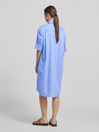 Männermodel trägt Relaxed Fit Hemdblusenkleid mit Brusttaschen Modell 'Daliya' von JOOP!, niebieski, pasiasty nadruk z logo na całej powierzchni, elastyczna mieszanka bawełny, kołnierzyk koszulowy, rękaw o dł. 1/2, listwa guzikowa, długość tyłu w rozmiarze 36: 108 cm, szerokość w rozmiarze 36: 52 cm, długość rękawów w rozmiarze 36: 30 cm, Ganzkörperansicht Rückansicht
