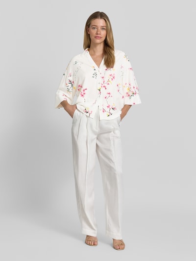 Vrouwenmodel draagt Relaxed Fit blouse uit mix van viscose en linnen model 'Lavisco' van FREE/QUENT met all-over look, overhemdkraag, V-hals, 3/4-mouw, ruglengte maat S 67 cm, mouwlengte maat S 30 cm, lichte kleuren met bloemenprint, losse rechte vormen, zachte textuur. Volledige lichaamsaanzicht van voren.