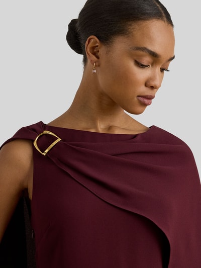 Vrouwenmodel draagt Tailliertes Cocktailkleid mit Umhang van Lauren Ralph Lauren, uni-look, getailleerde fit, mini-lengte, bordeauxrood, metallic accenten, mouwloos, detailopname bovenlichaam.