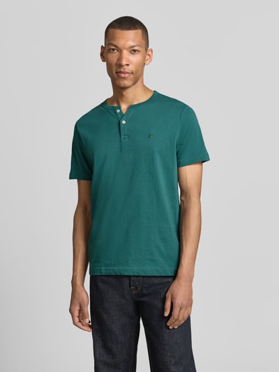 Männermodel trägt T-Shirt mit kurzer Knopfleiste von Lerros in Grün, Reine Baumwolle, Gerader-Schnitt, Rundhalsausschnitt, Logo-Stitching, Rückenlänge 69 cm bei Größe M, Ganzkörperansicht von vorne.