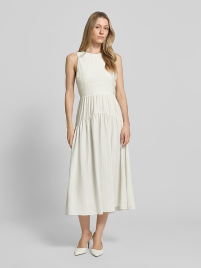 Frauenmodel trägt Cocktailkleid mit Cut Out im Rücken von Little Mistress in Creme, Taillierter Schnitt, Midikleid, Rundhalsausschnitt, Rückenlänge 120 cm, Ganzkörperansicht von vorne.