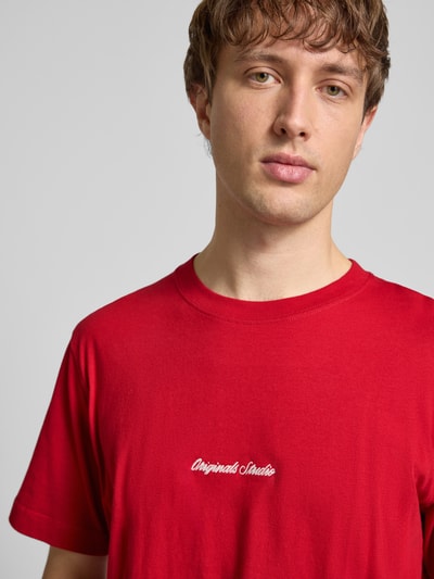 Männermodel trägt T-Shirt mit Label-Stitching Modell 'NORREBRO' von Jack & Jones, rot, reine Baumwolle, Nahaufnahme Oberkörper.