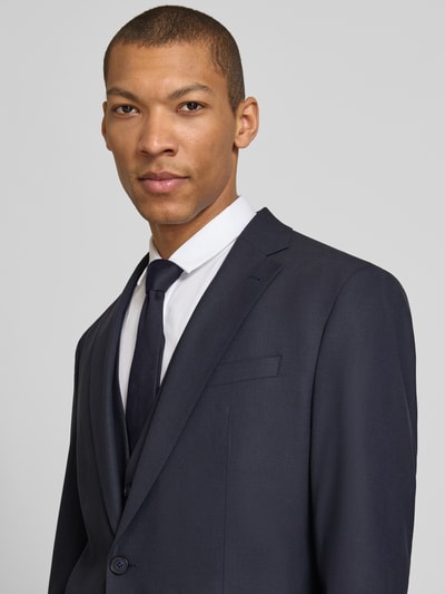 Männermodel trägt Slim Fit Sakko mit Schurwoll-Anteil Modell 'Totti' von CINQUE in Dunkelblau, feine Textur, Nahaufnahme Oberkörper. Elastischer Material-Mix, Reverskragen, Knopfleiste, Pattentaschen.