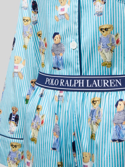 Mädchen trägt Comfort Fit Pyjama aus reiner Baumwolle Modell 'Iconic Bear' von Polo Ralph Lauren, niebieski w paski, nadruk z motywem misia, detal z logo na elastycznym pasku, popelina, detaliczne ujęcie przodu.