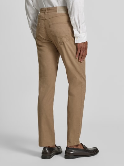 Męski model nosi Slim Fit Jeans im 5-Pocket-Design od Christian Berg Men, beżowa mieszanka bawełny, krój slim fit, długość nogawki 82 cm, szerokość w rozmiarze 32/32: 42 cm, zapięcie na guzik i zamek błyskawiczny, widok całej sylwetki z tyłu.