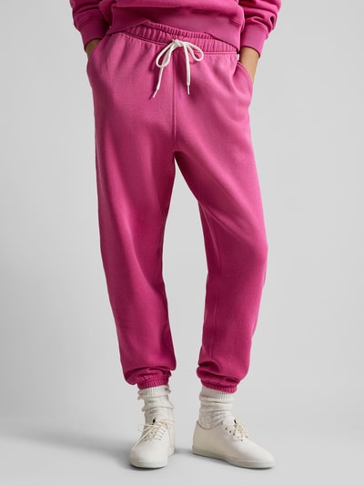 Frauenmodel trägt Comfort Fit Sweatpants aus reiner Baumwolle von Polo Ralph Lauren in Pink mit Tunnelzug, elastischem Bund und Logo-Stitching, seitliche Eingrifftaschen, Sweat-Material, unifarben, Ganzkörperansicht von vorne.