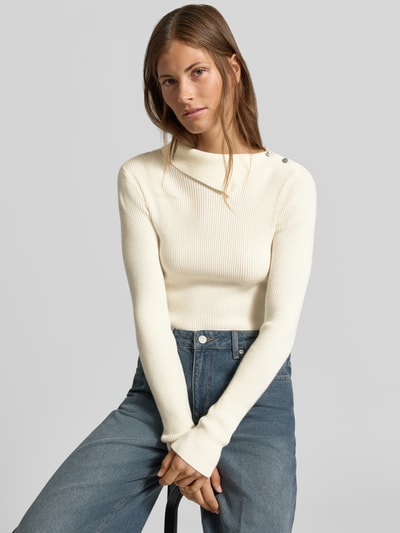 Frauenmodel trägt Slim Fit Pullover aus Viskose-Mix in Strick-Optik von MYON, cremefarben, mit Knopfleiste, Nahaufnahme Oberkörper.