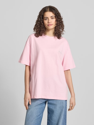 Frauenmodel trägt T-Shirt mit Logo-Stitching von ANOTHER COTTON LAB in Hellrosa, Reine Baumwolle, Lockerer-Schnitt, Rundhalsausschnitt, Überschnittene Schultern, Rückenlänge bei Größe S 66 cm, Ganzkörperansicht von vorne.