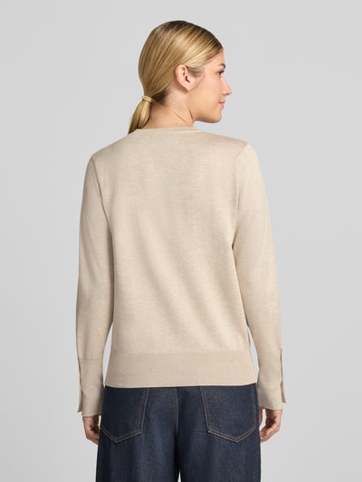 Vrouwenmodel draagt gebreide pullover van viscosemix Model 'KATIE' van FREE/QUENT, recht model, elastische boordjes, knopen aan de mouwboorden, ruglengte maat S 58 cm, mouwlengte maat S 66 cm, beige tinten, fijne structuur, detailarme achtergrond, geheellichaamsaanzicht achteraan.