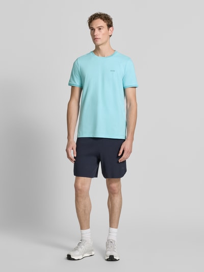 Męski model nosi jasnoniebieski t-shirt Regular Fit T-Shirt aus Baumwoll-Mix Modell 'TAUL' von BOSS Green, gładka faktura, krój regular fit, Ganzkörperansicht von vorne.