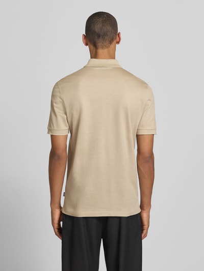 Männermodel trägt Regular Fit Poloshirt aus Baumwoll-Lyocell-Mix Modell 'H-PARAS 70' von BOSS in Beige, unifarben, Rückansicht.