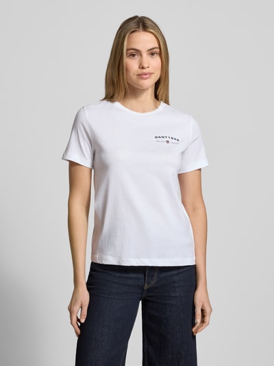 Kobiece model prezentuje T-Shirt mit Label-Print und Rundhalsausschnitt od Gant w kolorze białym, bawełna, regular fit, widok z przodu, ujęcie całej sylwetki.