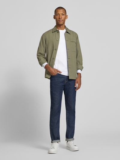 Männermodel trägt Longsleeve aus reiner Baumwolle von Christian Berg Men in Weiß, kombiniert mit Jeans, lockere Passform, Ganzkörperansicht von vorne.