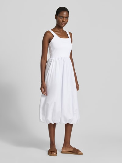 Frauenmodel trägt Ballonförmiges Midikleid im 2-in-1-Look von Rich & Royal, weiß, Baumwoll-Elasthan-Mix, Karree-Ausschnitt, ballonförmiger Schnitt, Ganzkörperansicht von vorne. Rückenlänge bei Größe S: 26 cm, Brustweite bei Größe S: 33 cm.