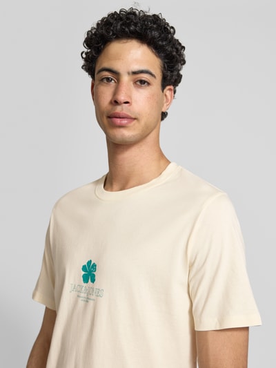 Männermodel trägt Regular Fit T-Shirt mit Logo-Print Modell 'Eres' von Jack & Jones, cremefarben, reine Baumwolle, Nahaufnahme Oberkörper.