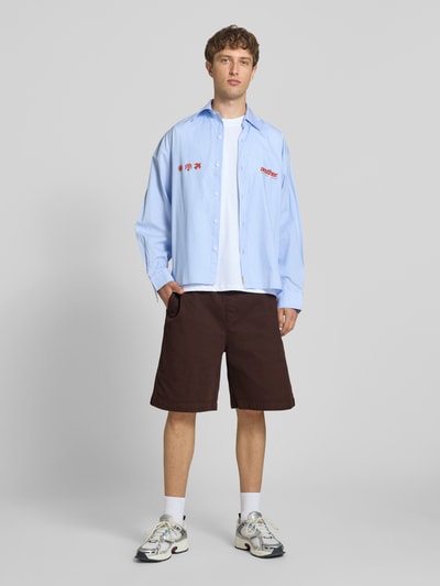 Mannenmodel draagt Shorts uit katoenmix Model 'Floyde' van Carhartt Work In Progress in bruin, relaxed fit, steekzakken, elastische band met tunnelkoord, bandwijdte maat M 39 cm, binnenbeenlengte maat M 25 cm, full-body voorkant.