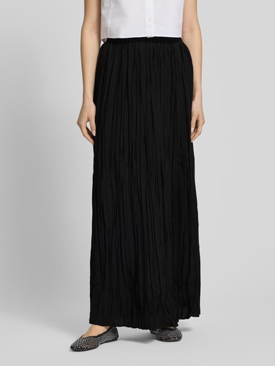Frauenmodel trägt Maxirock aus Viskose-Mix mit Strukturmuster Modell 'THEA' von Topshop in Schwarz, A-Linie, Nahaufnahme Oberkörper.