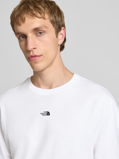Männermodel trägt T-Shirt mit Logo-Stitching von The North Face aus weißer Baumwolle, gerader Schnitt, Nahaufnahme Oberkörper.