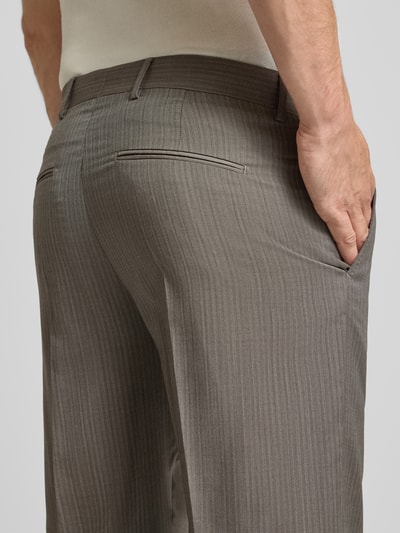 Mannelijk model draagt Anzughose aus Wolle mit Gesäßleistentaschen Model 'TENSE' van Tiger of Sweden in taupe met fijne strepen, detailopname. Regular fit, zuiver wol, haak-, knoop- en ritssluiting, persplooien, steekzakken aan de zijkant, strookzak aan de achterkant, bandwijdte maat 50: 48 cm, binnenbeenlengte maat 50: 80 cm.
