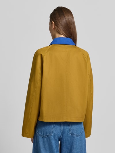 Männermodel trägt Kurze Barn-Jacket mit Kontrast-Kragen - curated by Tinvcb von SIC, żółty kolor, granatowy kołnierz, bawełna, krój relaxed fit, zamek, długość tyłu w rozmiarze 36: 56 cm, szerokość ramion w rozmiarze 36: 44 cm, szerokość klatki piersiowej w rozmiarze 36: 60 cm, długość rękawa w rozmiarze 36: 57 cm, widok całej sylwetki od tyłu.