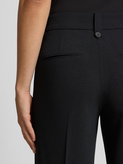 Frauenmodel trägt Regular Fit Weite Hose mit Bügelfalten Modell 'KALINA' von ONLY, schwarze Farbe, glatte Textur, Nahaufnahme Rückansicht, Damen Weite Hose von ONLY.
