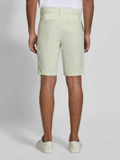 Männermodel trägt Tapered Chinoshorts aus Baumwoll-Mix Modell 'CHINO_TAPERED_DS_3S' von BOSS Orange, jednokolorowy, krój tapered fit, naszywka z logo, szlufki na pasek, zapięcie na guzik i zamek błyskawiczny, tunel, elastyczny pas, wpuszczane kieszenie boczne, kieszenie z tyłu, mieszanka bawełny, Ganzkörperansicht Rückansicht