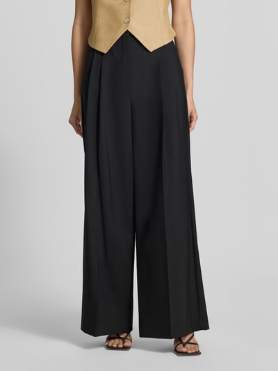 Frauenmodel trägt schwarze, weite Hose aus reiner Schurwolle, Modell 'OVVIO' von Max Mara, Damen Weite Hose von Weekend Max Mara, Nahaufnahme Unterkörper.