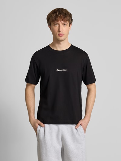 Männermodel trägt T-Shirt mit Label-Stitching Modell 'NORREBRO' von Jack & Jones, schwarze Baumwolle, Regular Fit, Nahaufnahme Oberkörper.