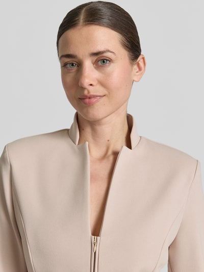 Frauenmodel trägt Jacke mit kurzem Reißverschluss von Rinascimento in Beige, taillierter Schnitt, Stehkragen, Material-Mix, Nahaufnahme Oberkörper.