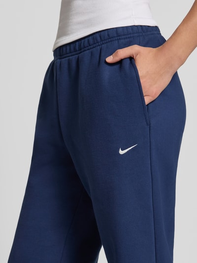 Vrouwenmodel draagt regular fit sweathose uit katoenmix van Nike in donkerblauw, Dames, detailopname heup en dij.
