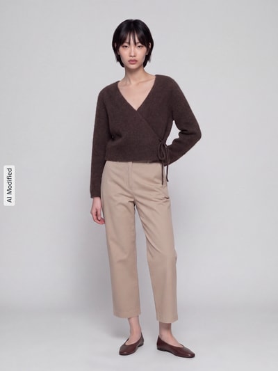 Frauenmodel trägt Relaxed Fit Strickjacke mit Wool-Anteil Modell 'LIVA' von ONLY in Braun, kombiniert mit beigen Hosen, Ganzkörperansicht von vorne, Damen Strickjacke von ONLY, KI-modifiziertes Bild.