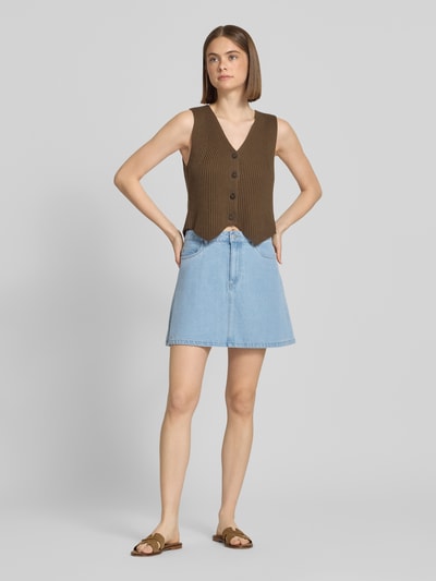 Vrouwenmodel draagt A-lijn jeansrok uit katoenmix met viscose, model 'ABBI' van Pieces, 5-pocket design, lichtblauw denim, mini, knoopsluiting, twill, voorkant volledig zichtbaar, ganzekörperaanzicht van voren.
