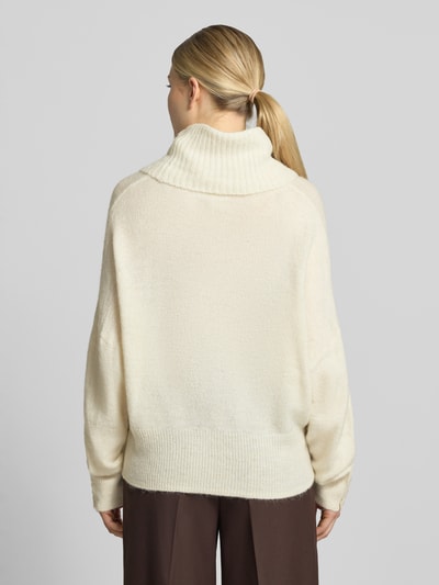 Modelka prezentuje sweter z dzianiny o kroju relaxed fit z golfem, Mieszanka materiałów z alpaki, Model 'IHKAMARA' od ICHI, Długość tyłu 63 cm, Długość rękawów 72 cm, elastyczne wykończenia, kremowy odcień, luźny krój, miękka faktura, widok całej sylwetki z tyłu.