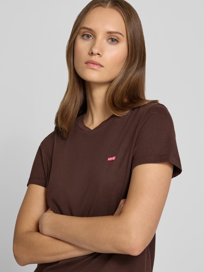 Frauenmodel trägt ein braunes Loose Fit T-Shirt aus reiner Baumwolle von Levi's®, glatte Struktur, Nahaufnahme Oberkörper.