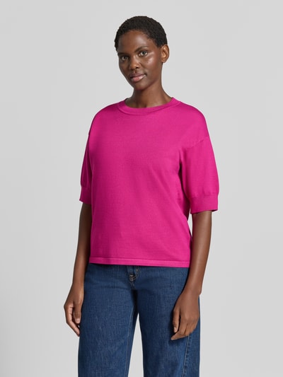 Kobiece modelka nosi Relaxed Fit T-Shirt aus Viskose-Mix od b.young, intensywnie różowy kolor, prążkowane wykończenia, okrągły dekolt, Mieszanka wiskozy, rękaw o dł. 1/2, długość tyłu w rozmiarze S: 56 cm, długość rękawów w rozmiarze S: 24 cm, widok całej sylwetki z przodu.