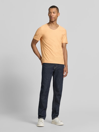 Mannenmodel draagt Regular Fit T-shirt met V-hals van MCNEAL in lichtoranje, puur katoen, rolzoom, ruglengte maat M 70 cm, full body vooraanzicht