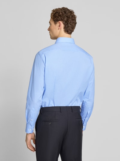 Männermodel trägt Modern Fit Business-Hemd mit Kentkragen von OLYMP in Hellblau und dunkler Hose, Ganzkörperansicht Rückansicht.